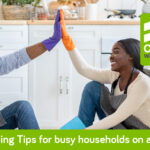 5 Cleaning tips for busy households on a budget African man and woman giving high five on clean floor, cleaning tips for busy households.