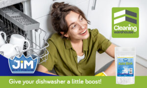 Smiling lady next to open dishwasher with JIM™ Auto Dish Salt bottle.