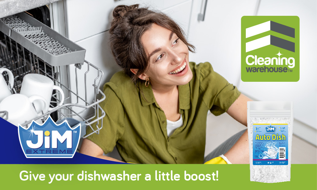 Smiling lady next to open dishwasher with JIM™ Auto Dish Salt bottle.