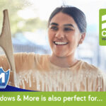 5 Tips to fast-track cleaning your home Lady smiling while cleaning a glass window with a squeegee and Window & More bottle.